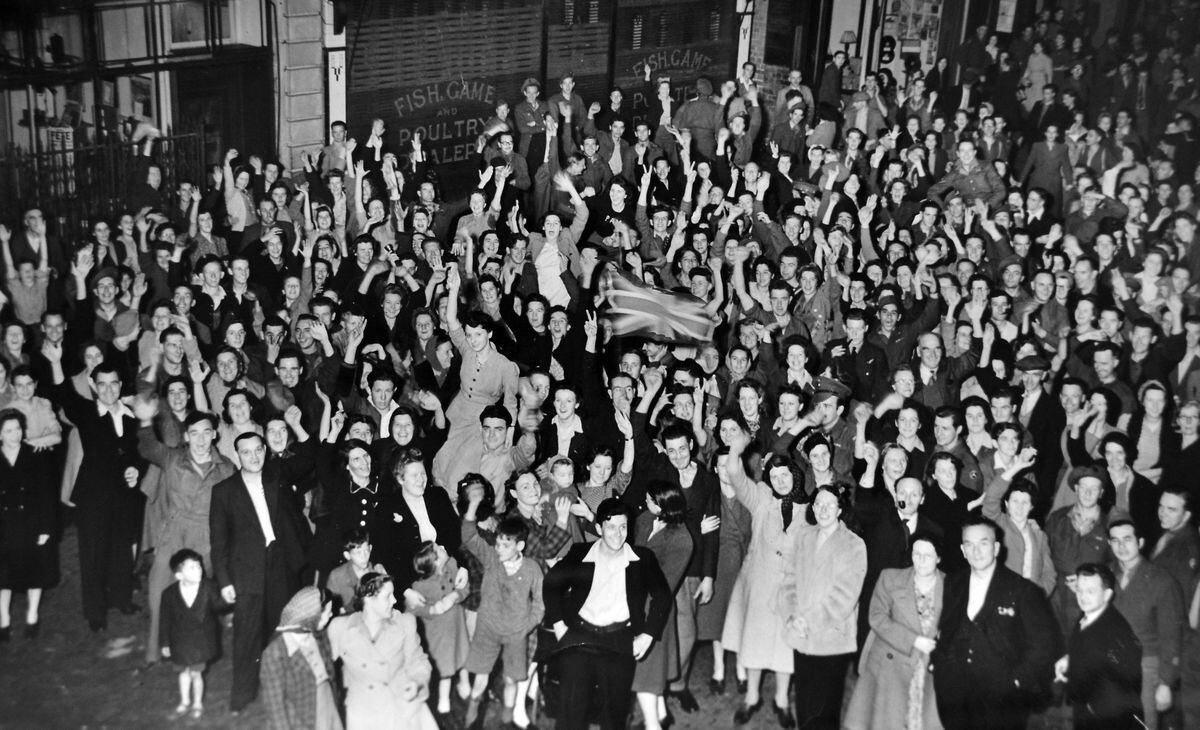 It's 1am on August 15, 1945, outside the American Red Cross Club, where jubilant Shrewsbury crowds lit a fire in the street.