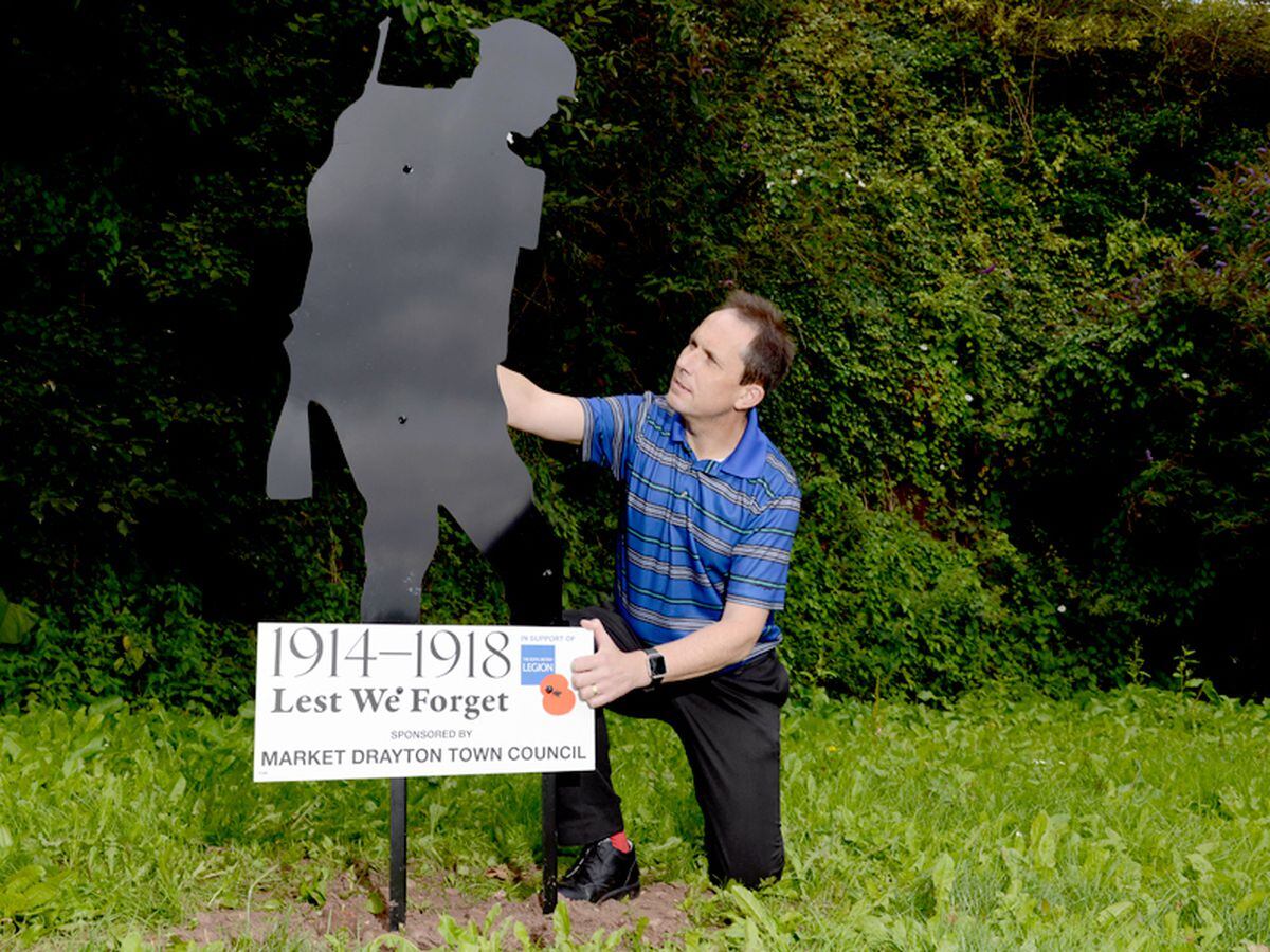 Councillor Tim Beckett with the life-size silhouette of a soldier which has now been fixed back into place