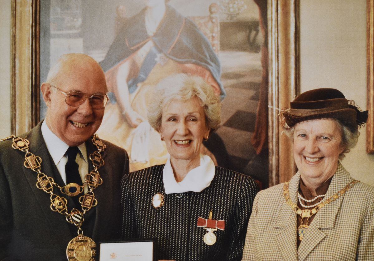 Margery, centre, receiving her BEM in 1990.