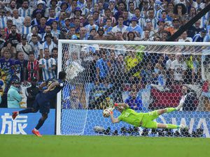 Argentina's goalkeeper Emiliano Martinez blocks a shot from France's Kingsley Coman in a penalty shootout during the World Cup final soccer match between Argentina and France at the Lusail Stadium in Lusail, Qatar, Sunday, Dec. 18, 2022. (AP Photo/Natacha Pisarenko).