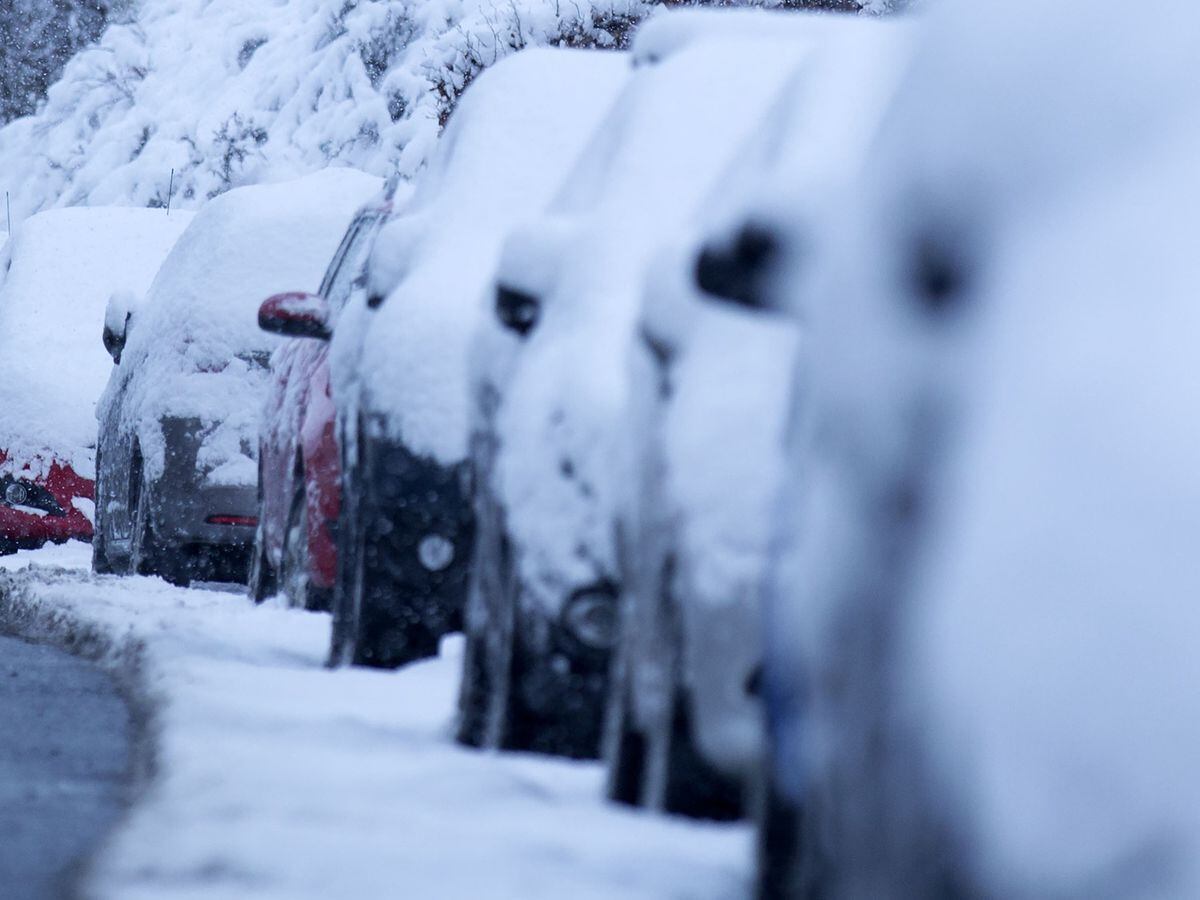 Cars covered with snow amid cold weather (David Cheskin/PA)