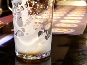 An empty pint glass on a bar