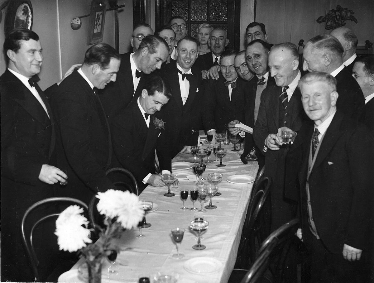 Gordon writes a note or perhaps his autograph at a special dinner for Shropshire sportsmen held at the Forest Glen at the foot of The Wrekin in December 1949.