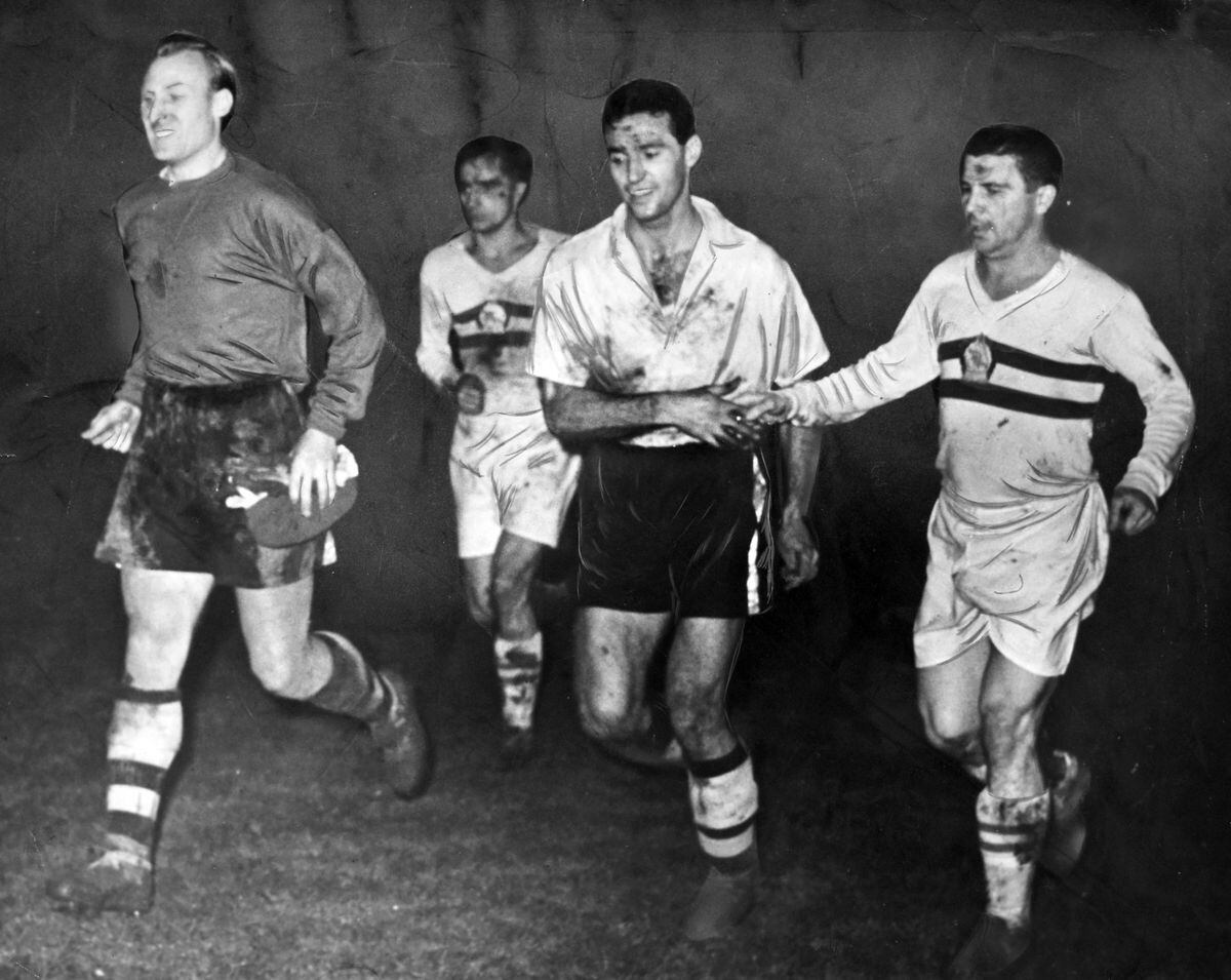 Wolves v Honved at Molineux, December 1954, in the luminous jerseys.  The original caption read: “Hungarian and Honved skipper Ferenc Puskas displayed his sportsmanship through a handshake for Wolves fullback Eddie Stuart as the teams walked off the pitch, Wolves stunned by success , Honved stunned by defeat.  Bert Williams (left) beamed happily under his Molineux mud cloak.