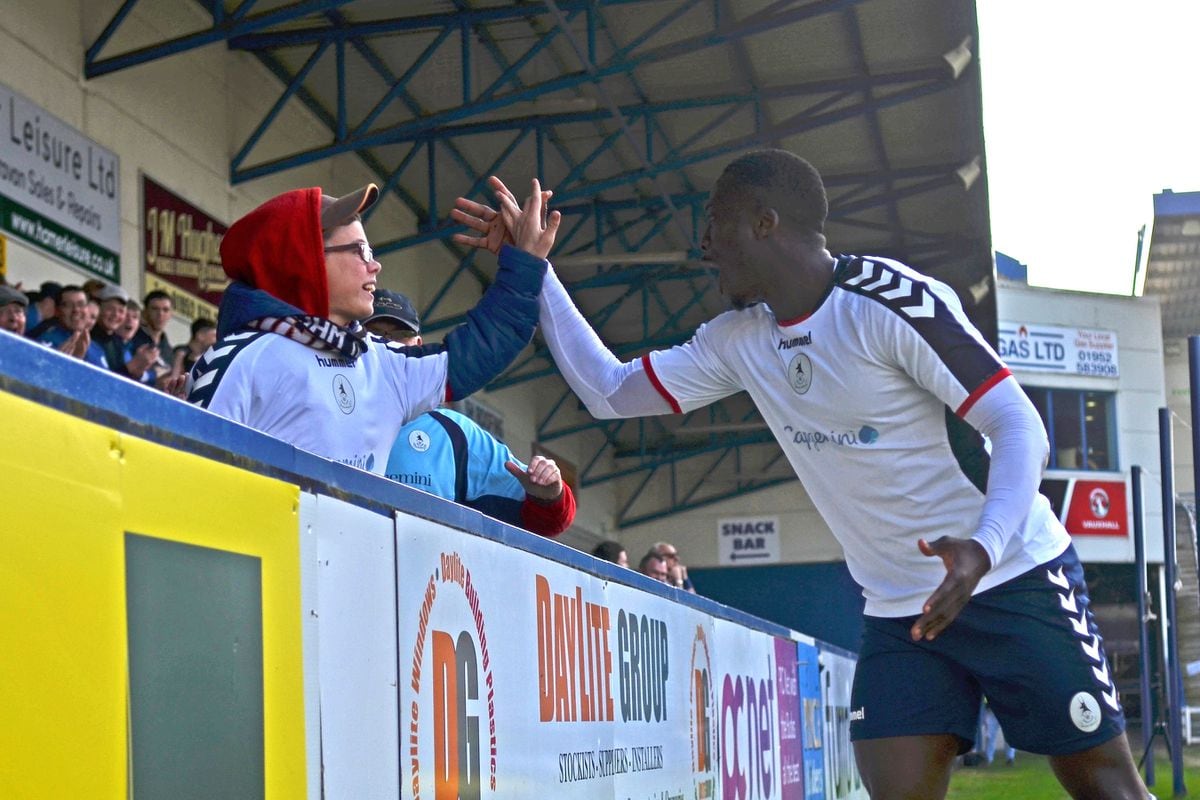 Dan Udoh of AFC Telford celebrates with a young fan after scoring to make it 1-0 during the Vanarama National League North fixture between AFC Telford United and Blyth Spartans at the New Bucks Head