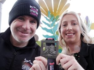 Fundraiser Bekki Fardoe with Alan Lewis from Adrenaline Sporting Events with the medal for the Welshpool 10K.
