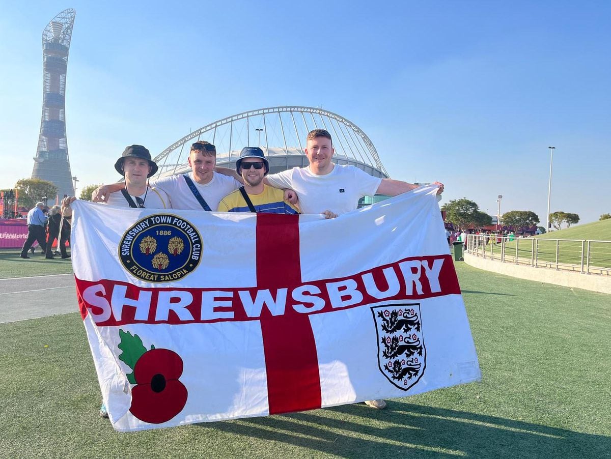 Jamie (in sunglasses) and the group with their Shrewsbury flag before the Iran game