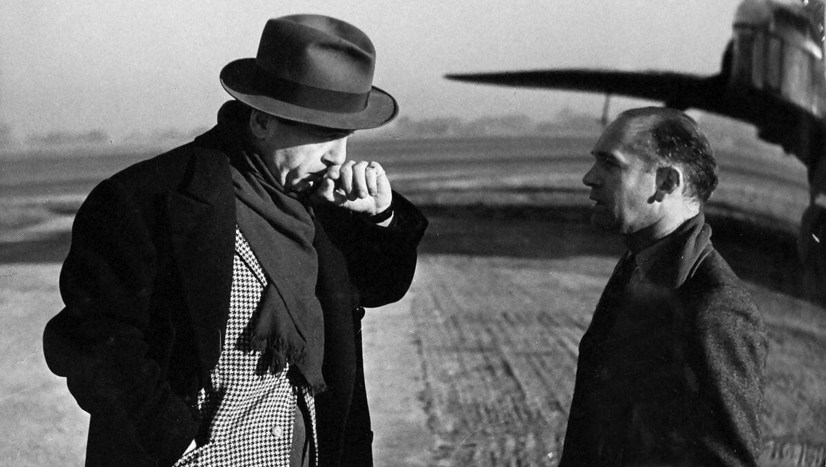 A chat for producer Paul Soskin and cameraman Osmond Borradaile during the shooting of the movie Signed With Their Honour at a Shropshire airfield in 1943. 