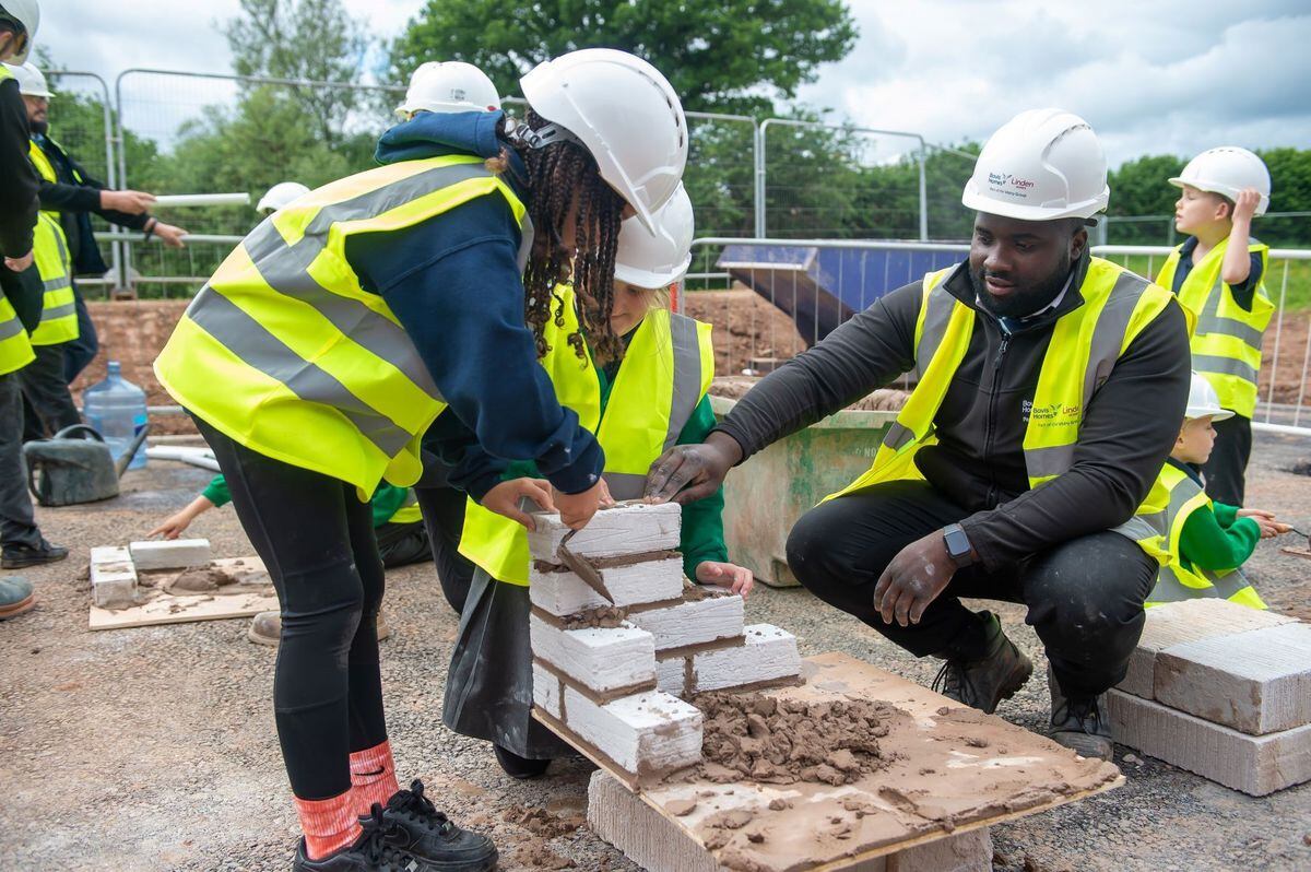 Reece Ramsay, assistant site manager, helping the pupils with bricklaying.