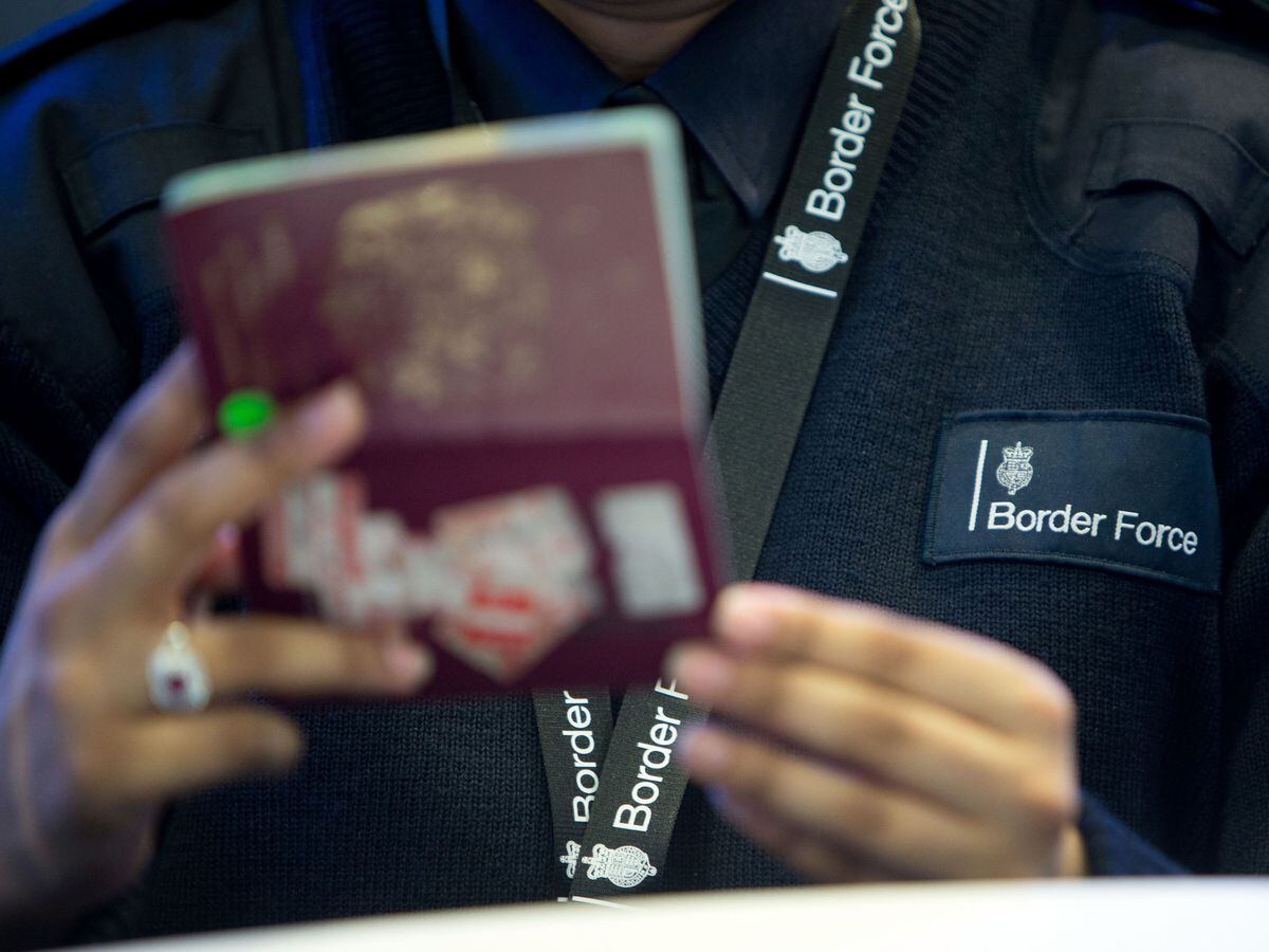 A Border Force officer checks passports