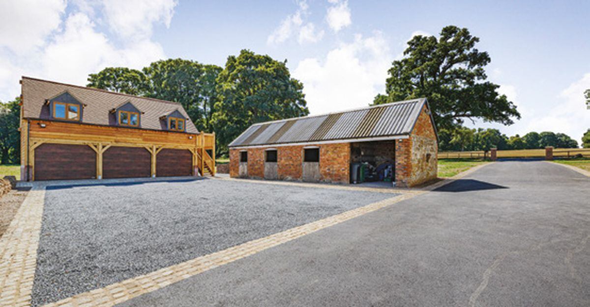 The triple garage has three electric up-and-over doors and adjacent to a separate stable block
