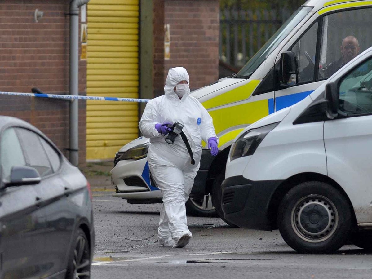 A forensic officer at the scene where a man was shot dead