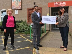 Hazel Holloway and Santhosh George present Cathy Thomas with the cheque
