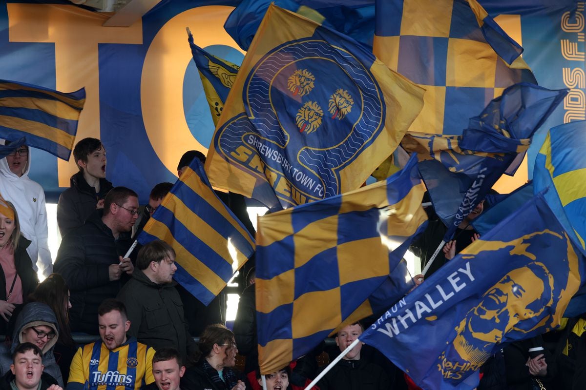 Fans of Shrewsbury Town wave flags. (AMA)