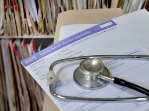 A stethoscope and a GP registration form