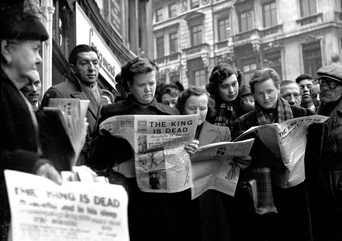 Serious faces on lunch time crowds reflect the tragic news of the death of King George VI, in Ludgate Circus, London