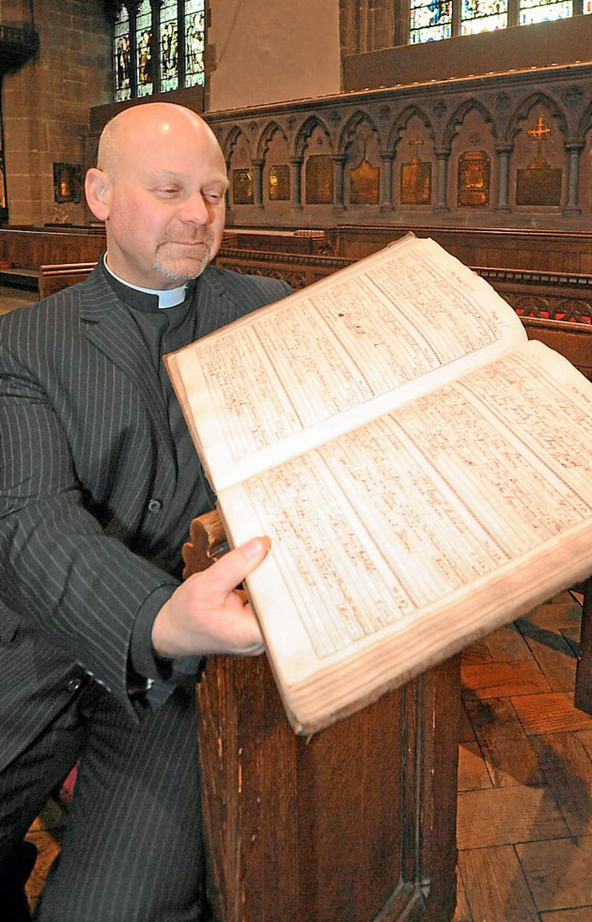 Rector of St Peter's Church in Wolverhampton, the Rev David Wright, looks at the record of Button Gwinnett's marriage to Ann