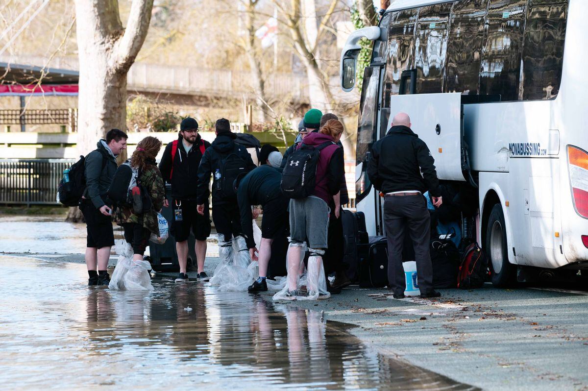 The dancers make it to a coach across the flooding