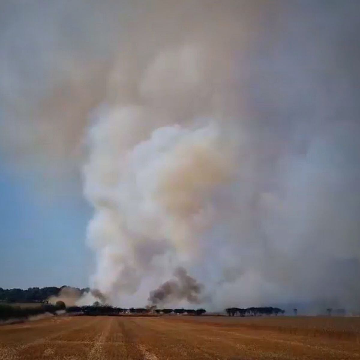 A huge plume of smoke rising into the sky.