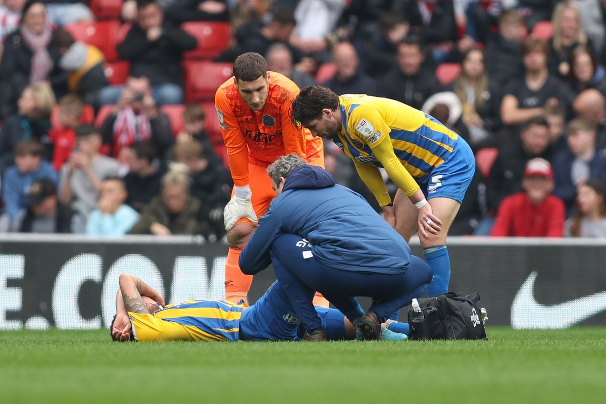 Elliott Bennett of Shrewsbury Town leaves the games with a first half injury (AMA)