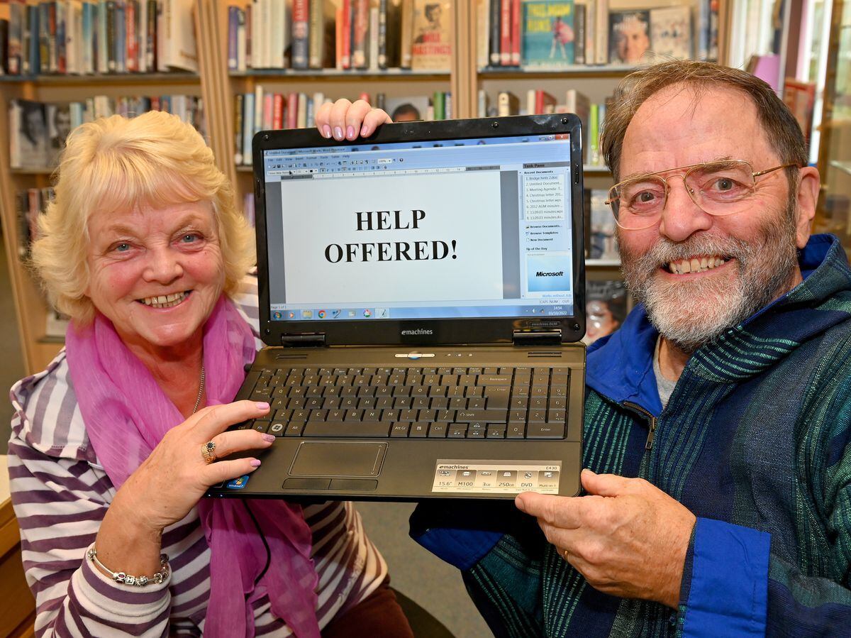 Volunteer teacher Chris Tatam helps visitor Sheila Ottolini with her IT skills at Market Drayton Library