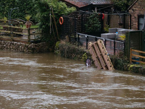 Debris collects as water comes perilously close to a home near Ironbridge
