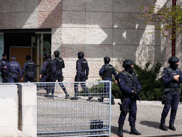 Police officers stand at the main entrance to an Ismaili Muslim centre in Lisbon