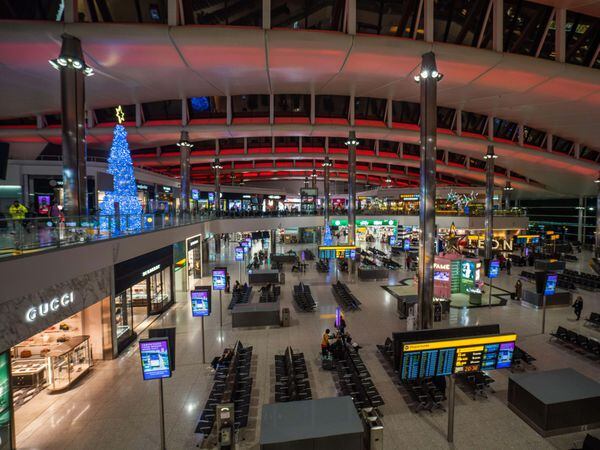 An illuminated Christmas tree displayed in a quiet Terminal Two at Heathrow