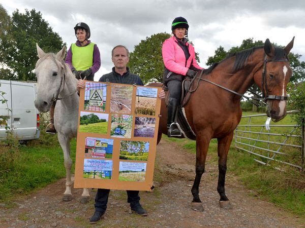SOUTH COPYRIGHT SHROPSHIRE STAR STEVE LEATH 27/09/2022..Pic on the outskirts of Ludlow, where residents are not happy about farmland being turned into a solar farm.  Pictured with the sign is actor: Tim Wallers, and with im is: Helen Munro on Joey and Maggie Anderson on Nelson..