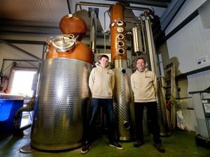 BORDER COPYRIGHT SHROPSHIRE STAR STEVE LEATH 07/04/2022..Pic in Oswestry for a feature with the Henstone Distillery (based at Stone H0use Brewery). Father and son: Chris and Henry Toller (from Oswestry), are pictured, filling bottles with booze, packaging it, with the large still and also a small copper one too, and with there barrells which are former American Bourbon Barrells..