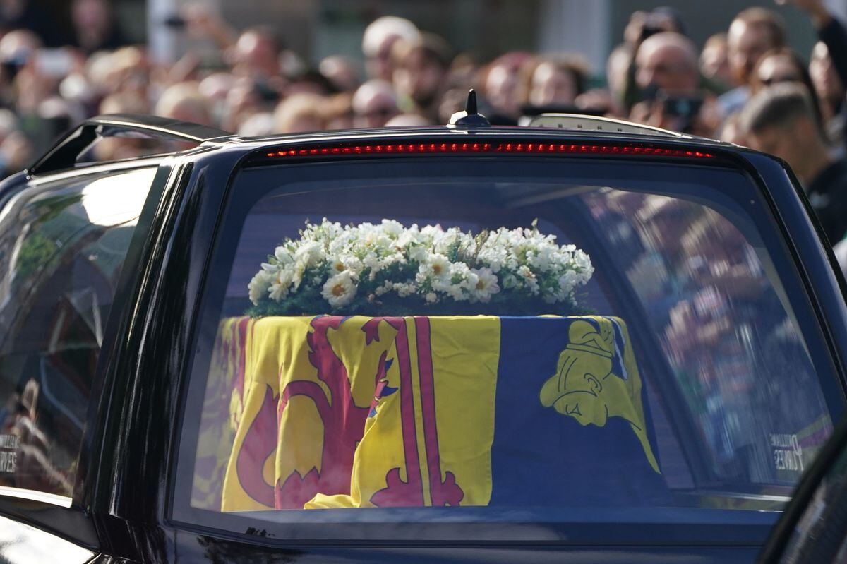 The hearse carrying the coffin of Queen Elizabeth II, draped with the Royal Standard of Scotland, passing through Ballater shortly after leaving Balmoral. Photo: Andrew Milligan/PA Wire