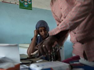 Surgeon and doctor-turned-refugee, Dr Tewodros Tefera, prepares a malaria test for 23-year-old Tigrayan refugee Hareg from Mekele, Ethiopia, at the Sudanese Red Crescent clinic in Hamdayet, eastern Sudan, near the border with Ethiopia