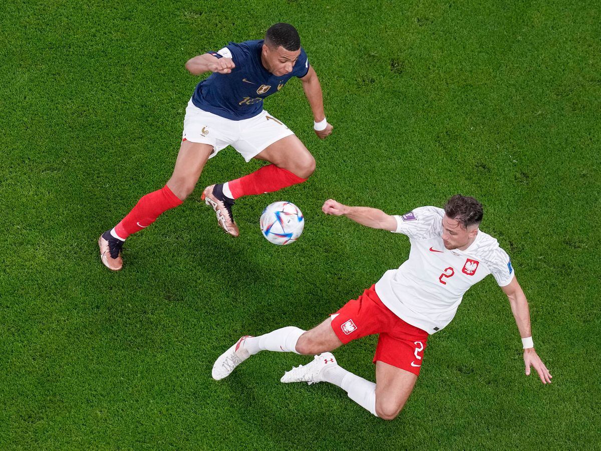 France’s Kylian Mbappe fights for the ball with Poland’s Matty Cash