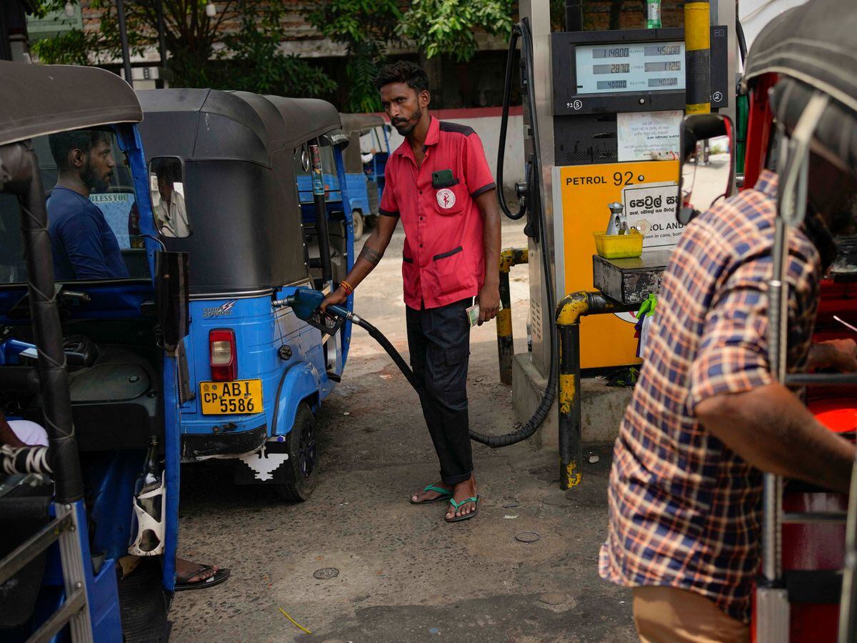 A man puts fuel into a vehicle at a petrol station in Colombo, Sri Lanka