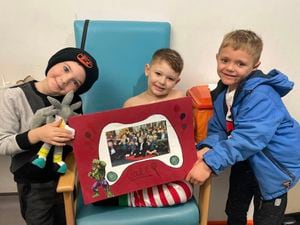 Charlie Wilkins with Jake Knowles, both aged six, and five-year-old Jayden Bow, with the card from pupils at Brown Clee Primary School.