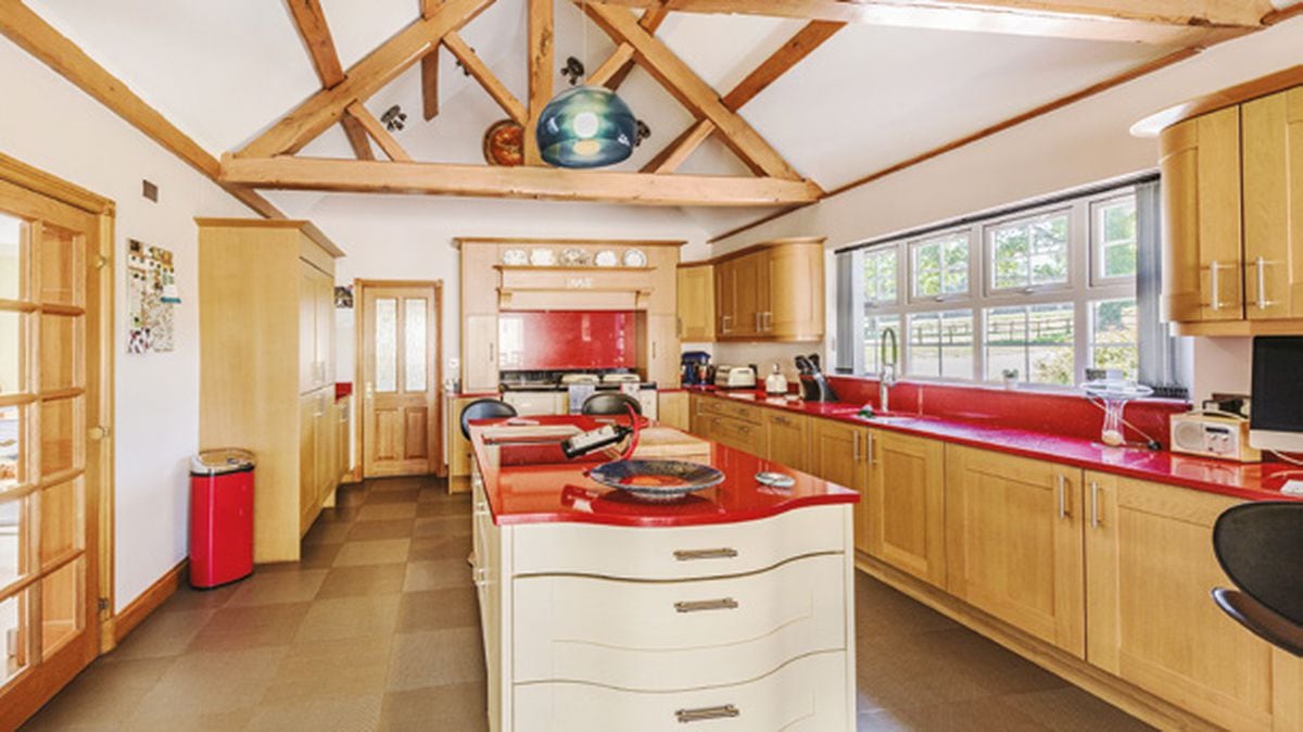 Red worktops adorn the units in the kitchen