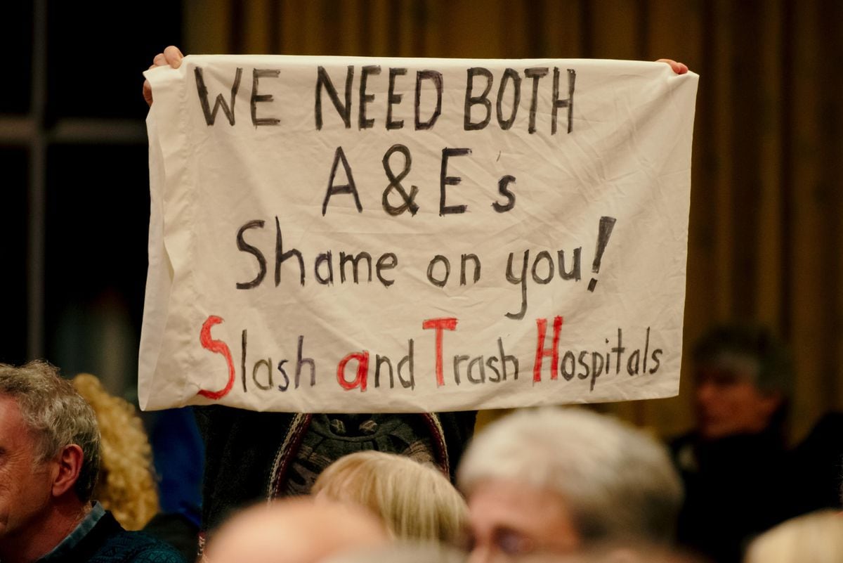 A protestor holds up a banner at the Future Fit decision-making meeting in 2019