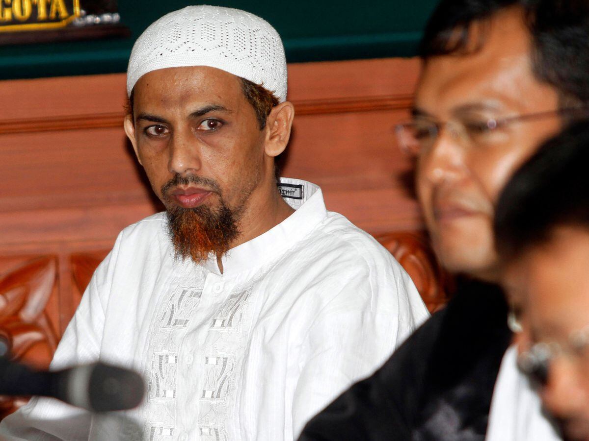 Umar Patek, an Indonesian militant charged in the 2002 Bali terrorist attacks, left, sits with his lawyer during his trial in Jakarta, Indonesia
