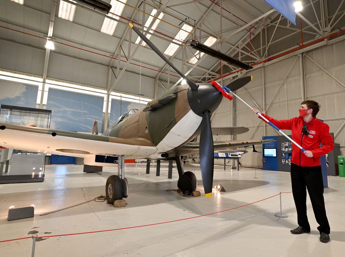 Visitor experience assistant Louis Cawkwell dusts down the Spitfire at RAF Cosford Museum
