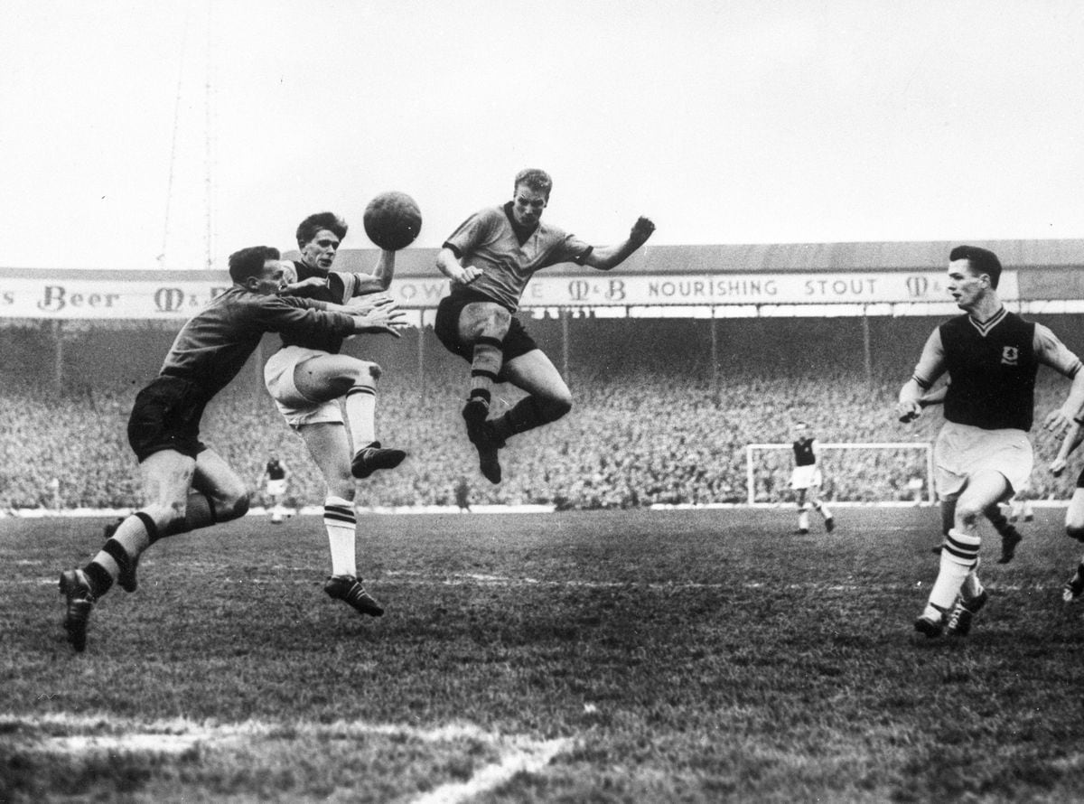 Wolverhampton Wanderers goalkeeper Malcolm Finlayson saves from Aston Villa's centre-forward Gerry Hitchens (centre) during the FA Cup semi-final held at The Hawthorns. On the right is Wolves left-half Ron Flowers..