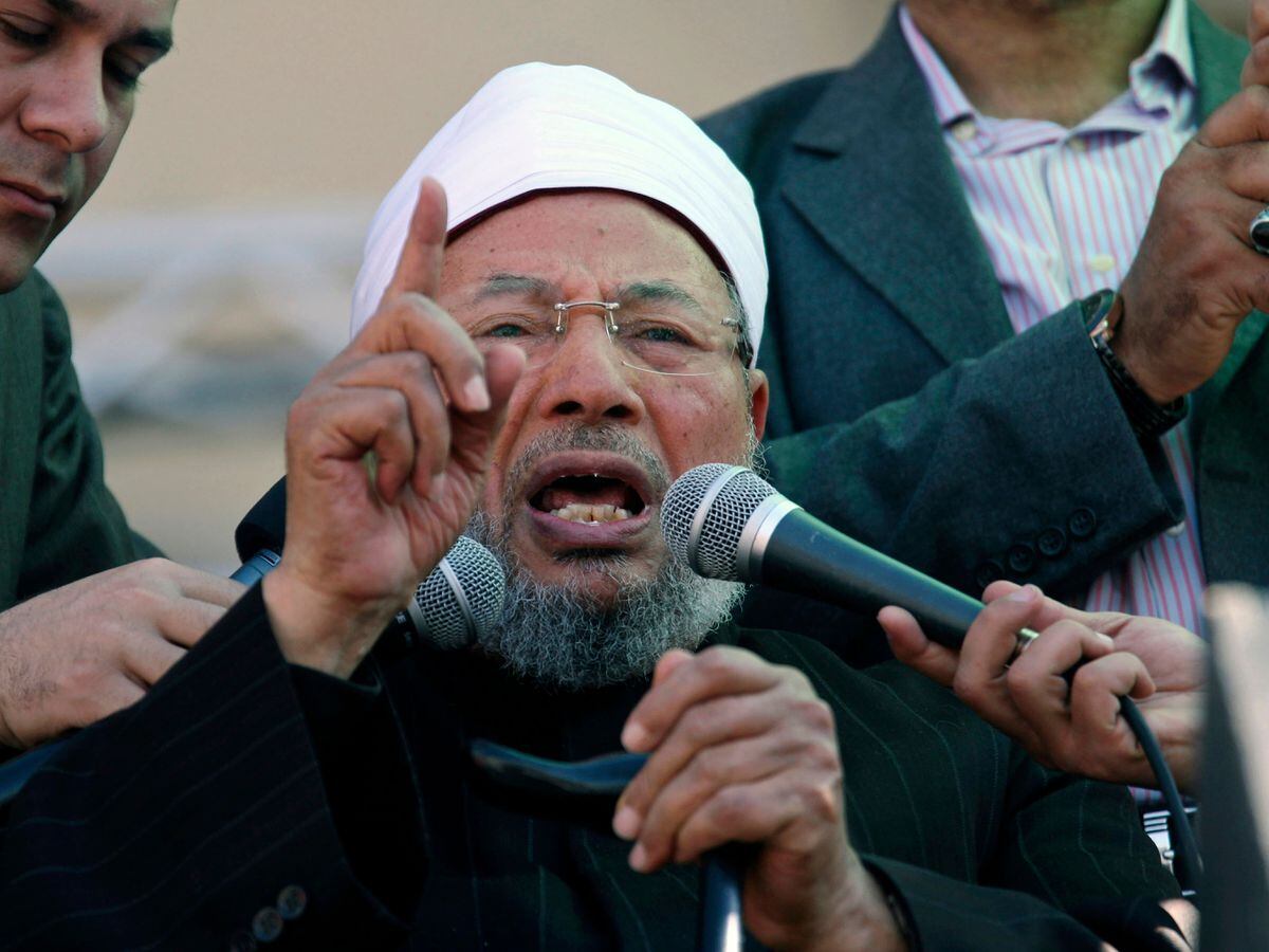 Sheik Youssef al-Qardawi speaks to the crowd as he leads Friday prayers in Tahrir Square in Cairo, Egypt in 2011