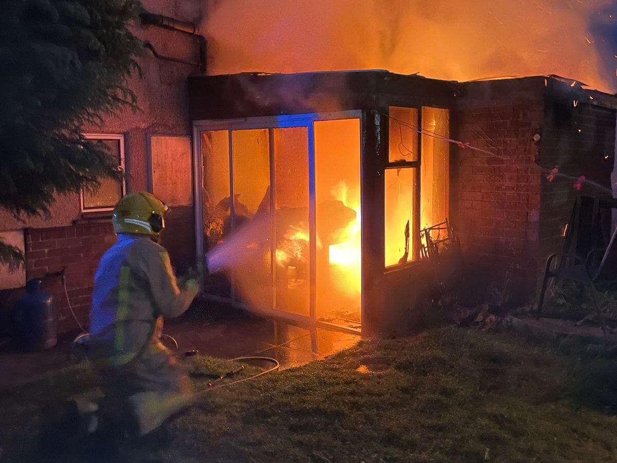 A firefighter attacks the fire in the conservatory. Photo: Market Drayton Fire Station