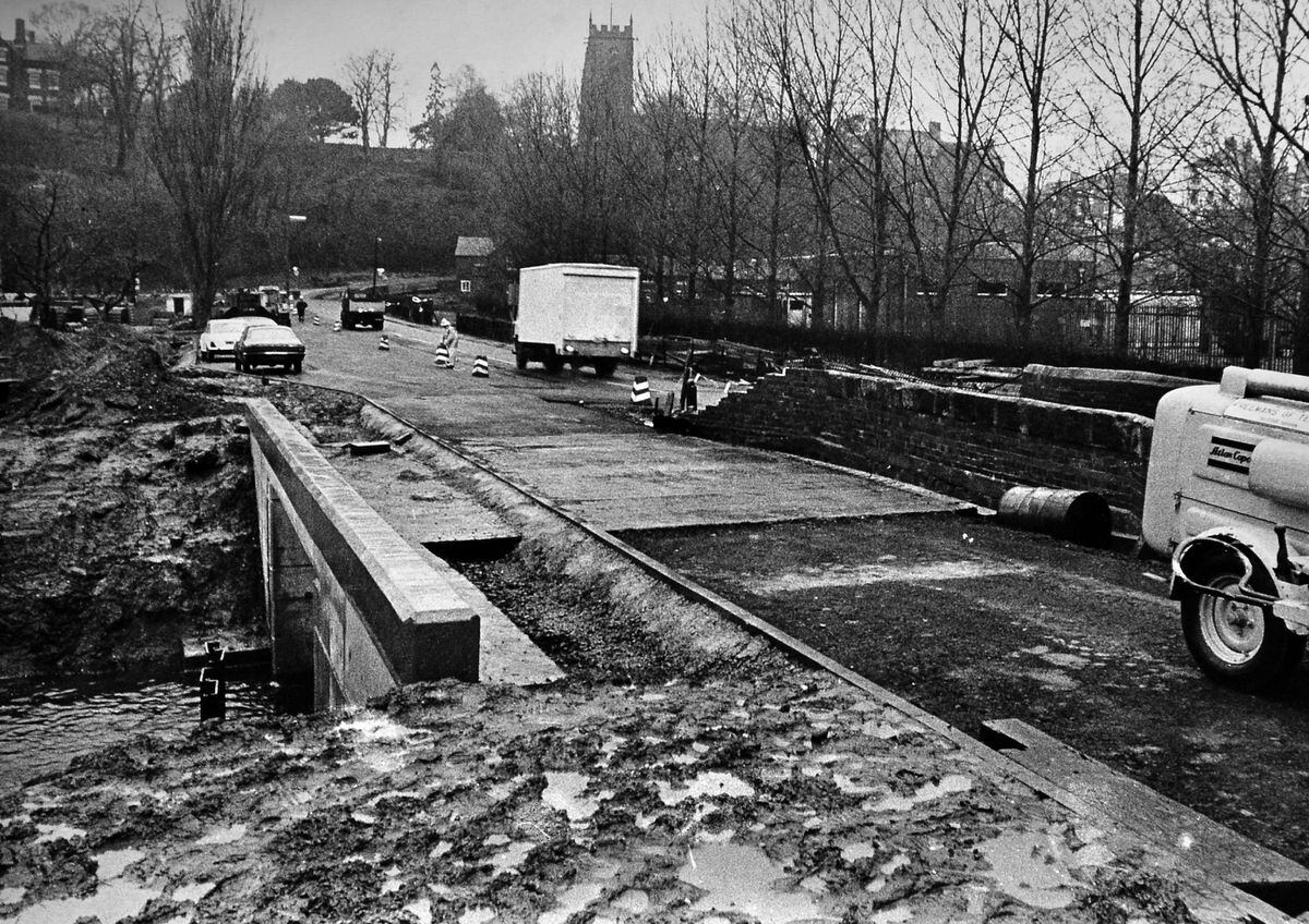 Work to replace the bridge that carries the Newport Road into town, in January 1974. Written on the back is: 'Work is well underway on the road improvements on the Newport Road at Market Drayton. Half of the new, wider bridge to replace the old narrow Tern Bridge is nearing completion. When it is, traffic will be diverted and the other part of the bridge built. The road is being widened in the project due for completion in the summer.'
