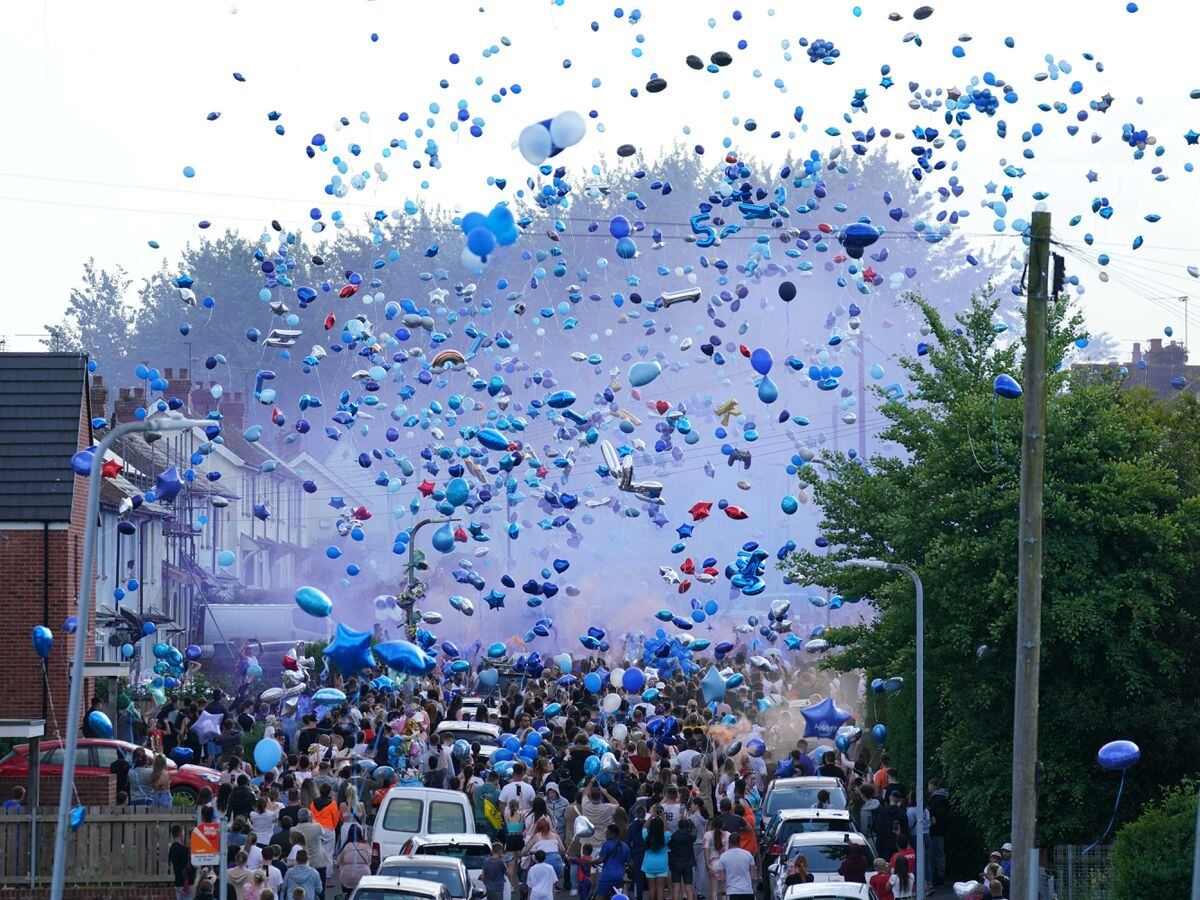 People release balloons during a vigil for the victims of a road traffic collision on Snowden Road in Ely, Cardiff (Jacob King/PA)