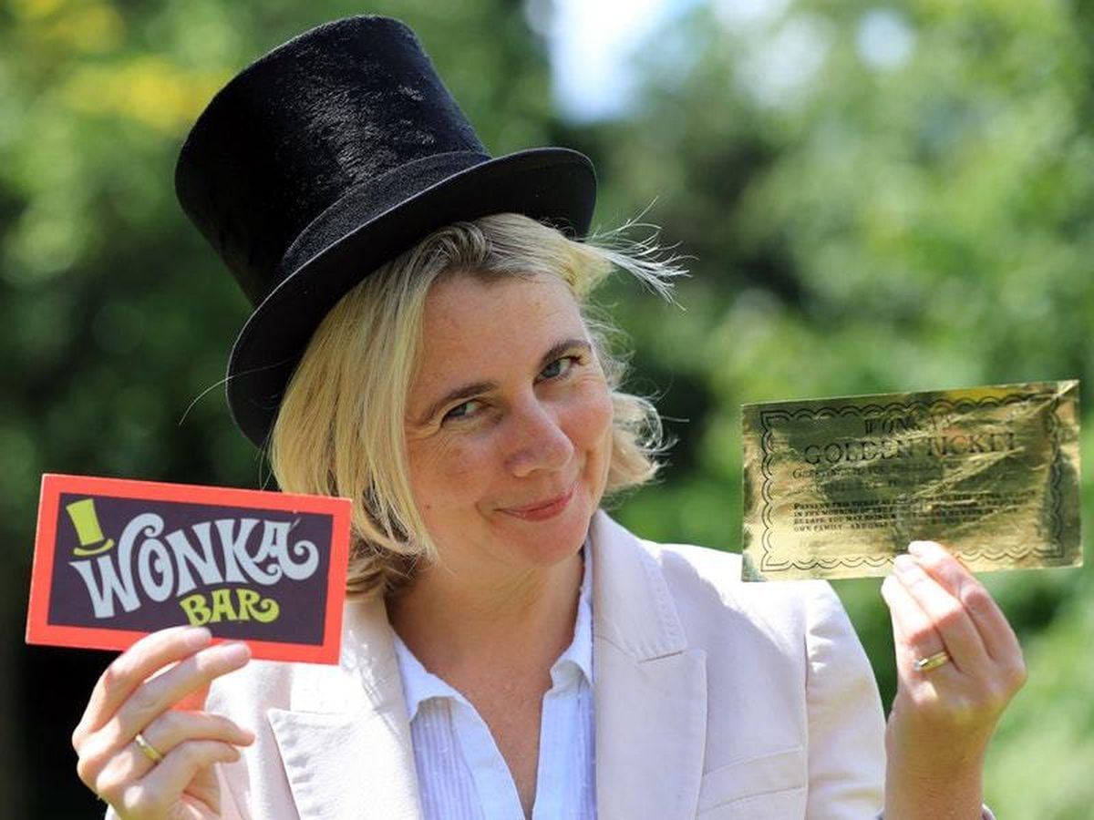 Auctioneer Catherine Southon holds the Golden Ticket and Wonka Bar
