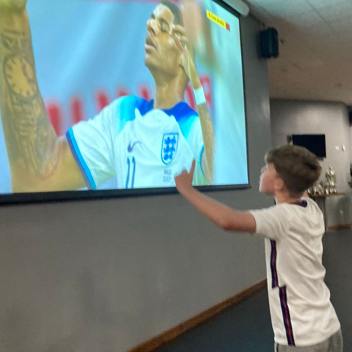 A young England fan celebrates as Rashford scores