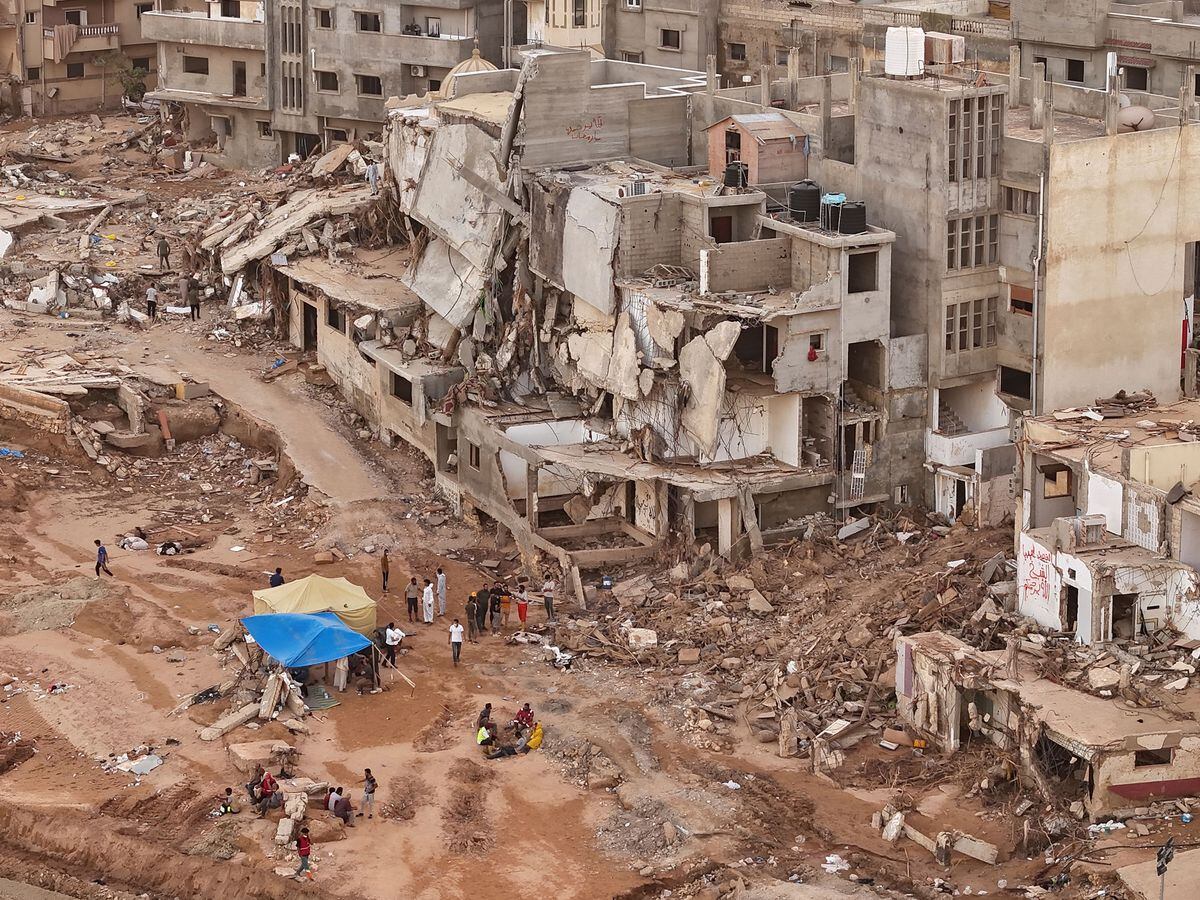 Rescuers and relatives of victims set up tents in front of collapsed buildings in Derna