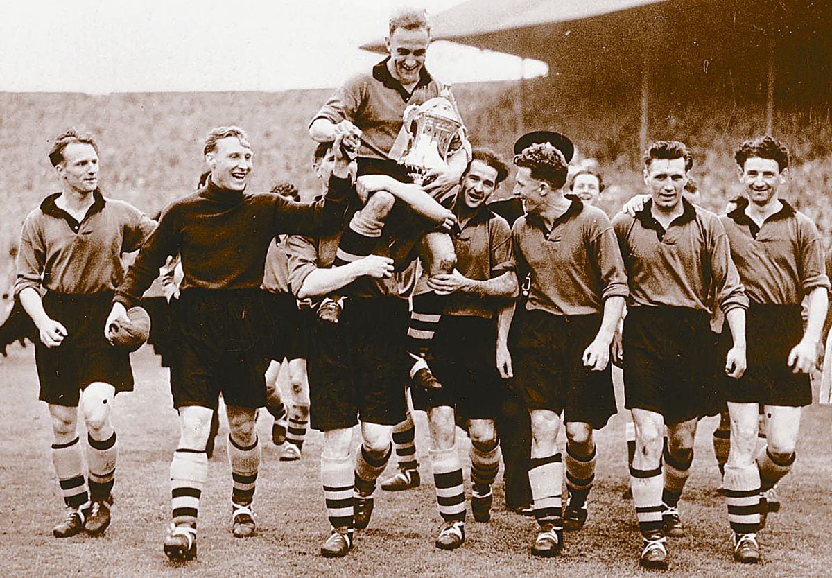 Being held aloft with the FA Cup after Wolves won it in 1949. 