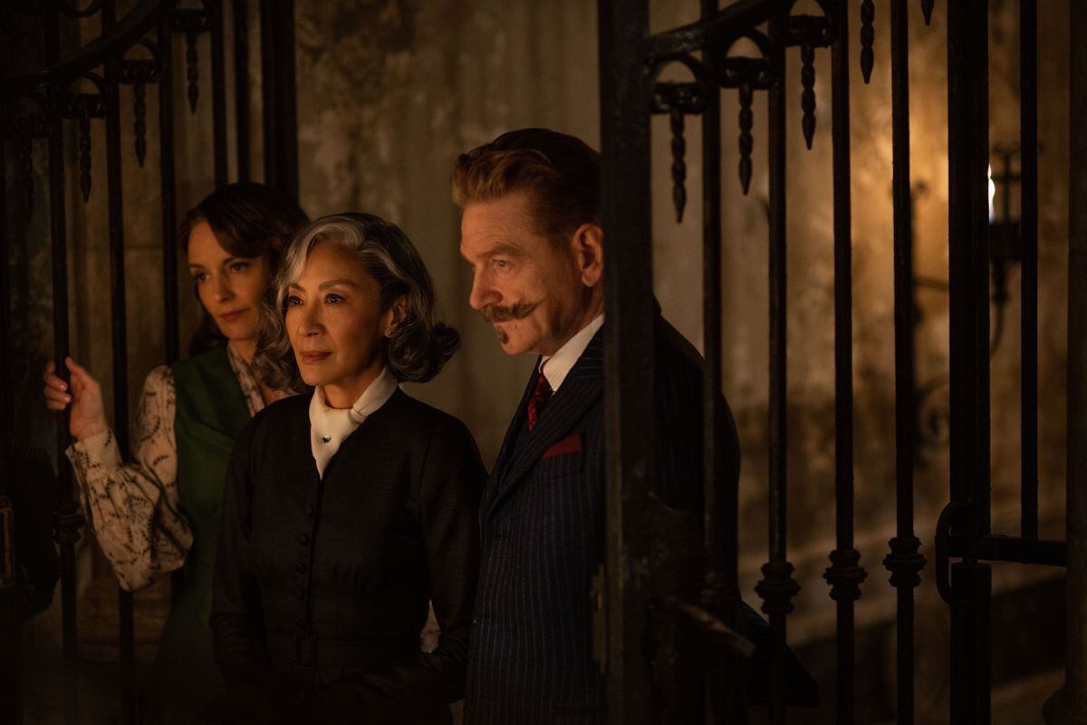 Tina Fey as Ariadne Oliver, Michelle Yeoh as Mrs Reynolds, and Kenneth Branagh as Hercule Poirot