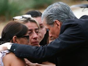 The archbishop of San Antonio, Gustavo Garcia-Siller, comforts families
